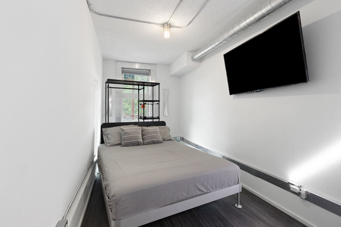 Furnished bedroom with mounted TV